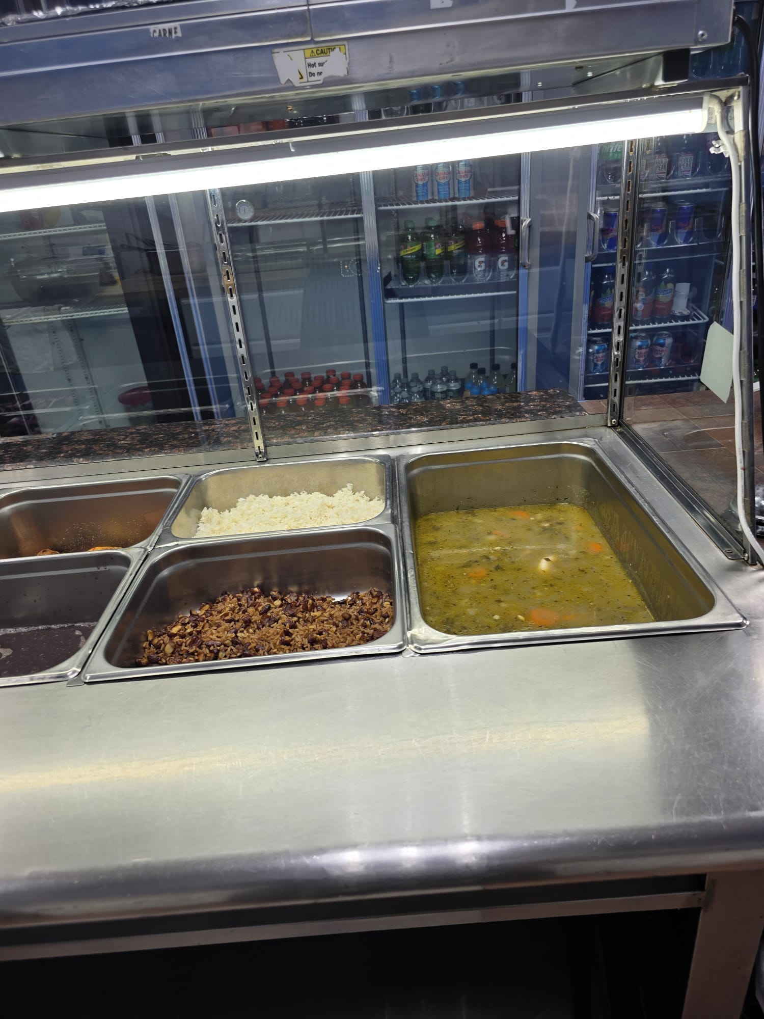 The hot food counter at Bristrot Chez Nous with rice, beans and soup