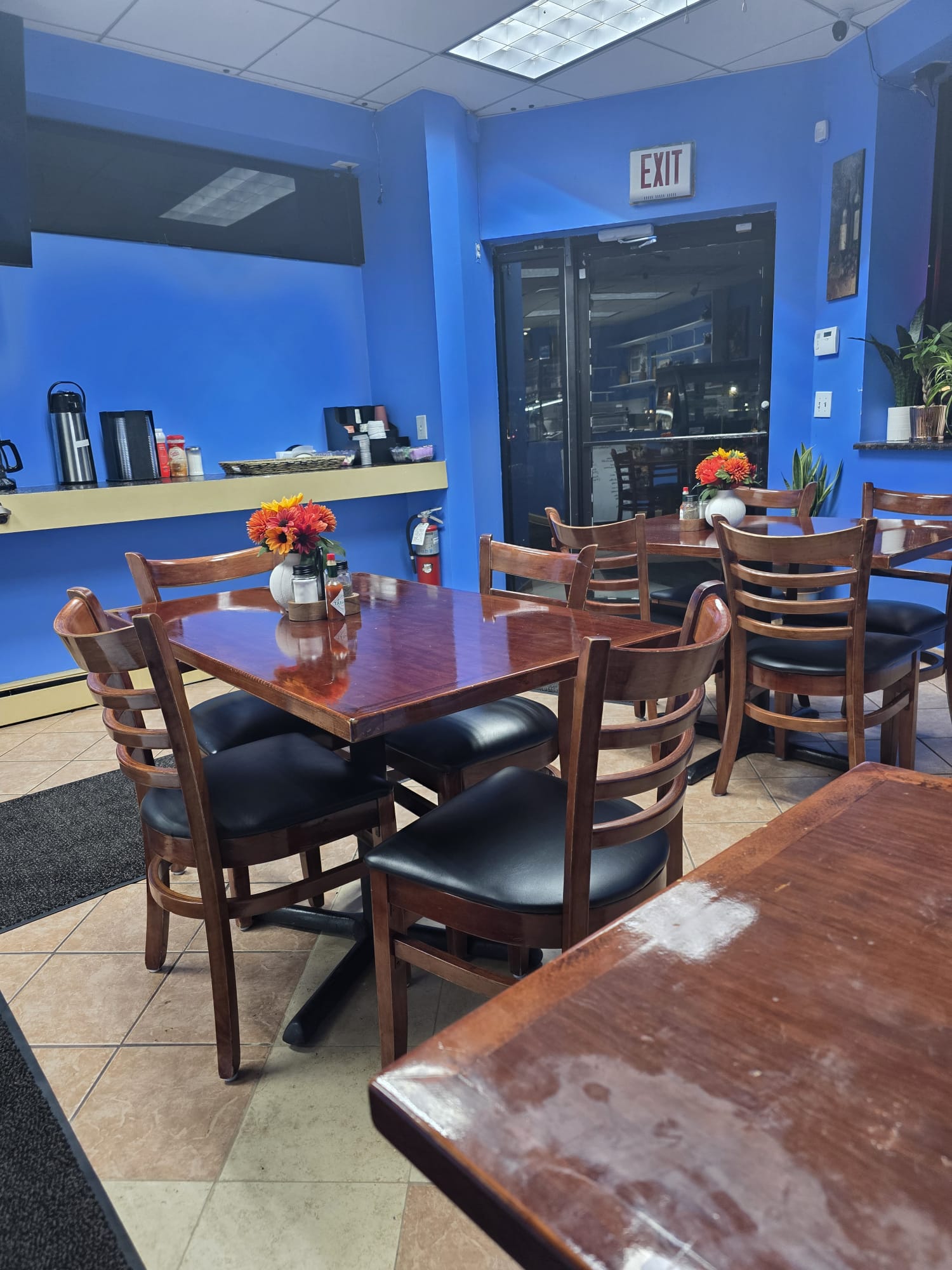 The dining room at Bristrot Chez Nous, with wooden tables and fresh flowers